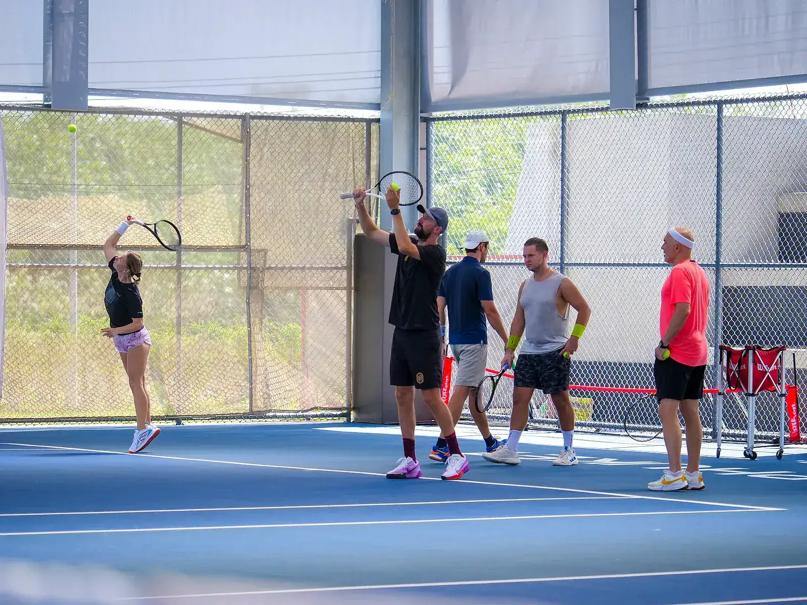 Members gathered on a covered court at the KĀHLĪ Tennis Academy, Phuket