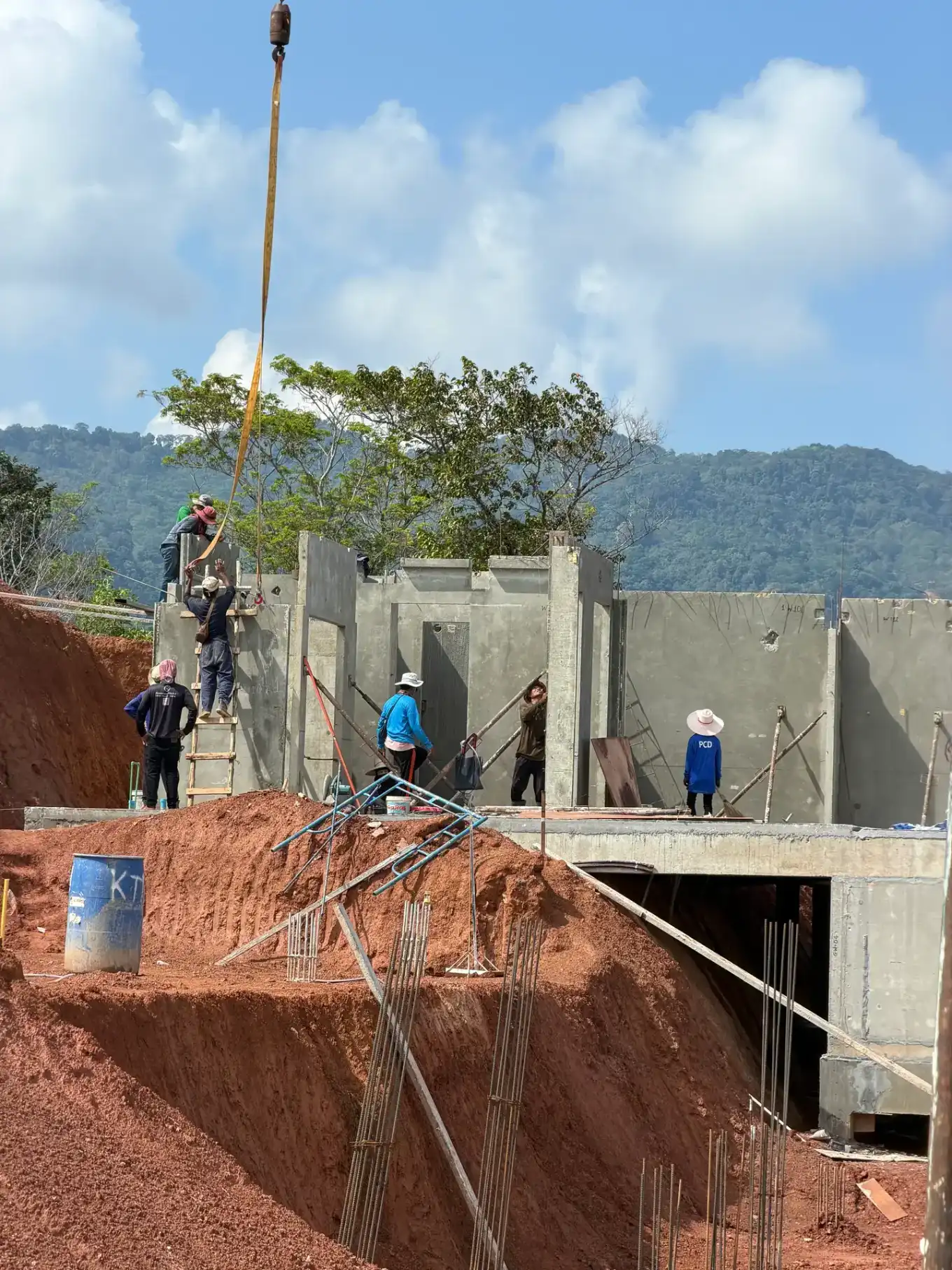 A precast concrete wall panel being craned into position at KĀHLĪ Phuket