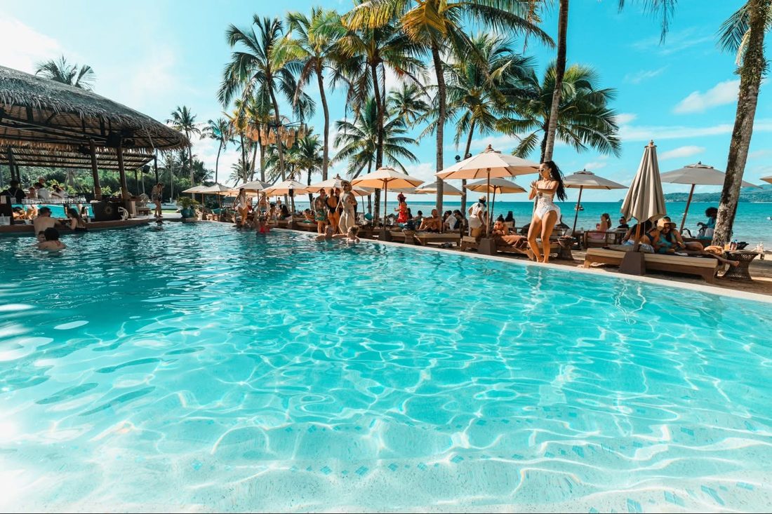 Poolside with umbrellas and palms at Carpe Diem Beach Club, Bangtao